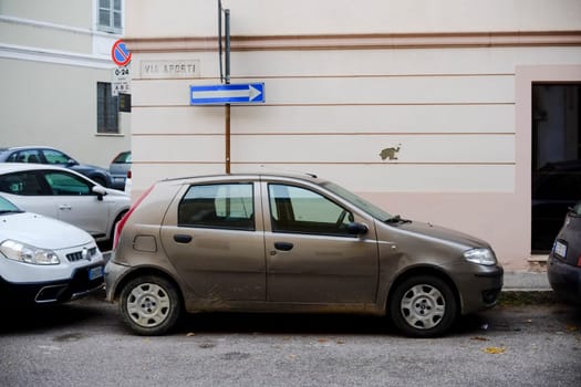 Cremona, Itally - October 6th 2024 Golden fiat punto 188 1.2 8v parked next to a no parking sign and a one-way street sign in a historic italian village