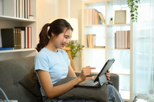 Pretty young woman in casual clothing watching video on digital tablet.