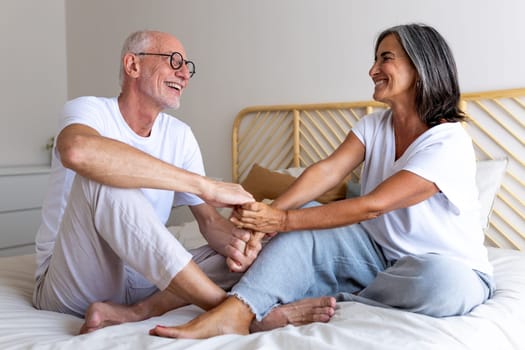 Affectionate happy mature couple in love looking at each other smiling, holding hands. Heterosexual couple concept.