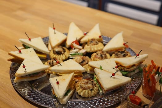 A beautifully arranged and visually appealing platter of assorted sandwiches that is perfect for any gathering