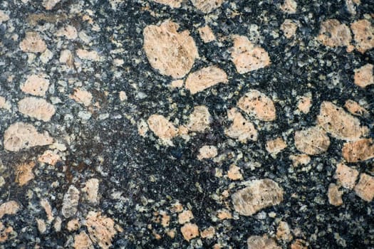 Macro shot of a polished granite surface, showcasing its varied mineral composition and intricate crystalline patterns