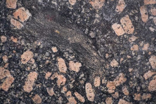 Polished granite surface showing feldspar crystals embedded in dark matrix.