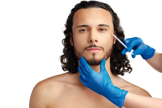 Man receiving cosmetic treatment with a syringe, showcasing a beauty procedure in a clinical setting