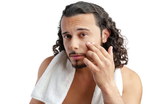 Smiling man with curly hair showing confidence while holding a towel in studio