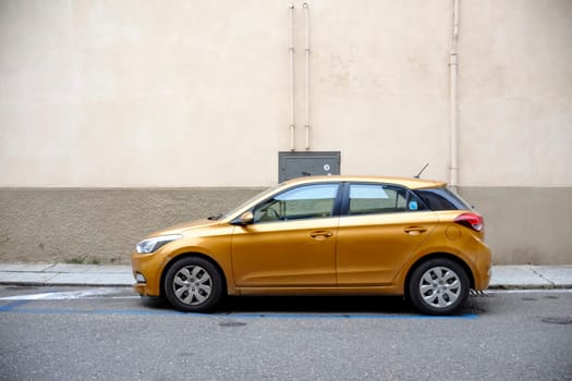 Cremona, Itally - October 6th 2024 Sleek, golden hyundai i20 parked neatly along a city sidewalk, embodying urban mobility and style