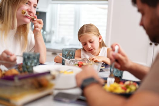 Family enjoying meal together in a modern kitchen close up