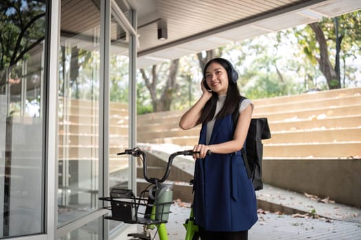 A woman enjoys music while promoting clean energy via cycling highlighting pollution reduction in urban settings.