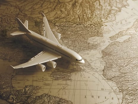 A small white model airplane placed on an aged, vintage world map. The warm tones and detailed map evoke themes of travel, exploration, and planning future journeys across the globe.