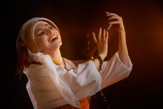 Dressed in colorful traditional clothing, a girl smiles brightly while holding an antique oil lamp, celebrating the story of Rebekah.