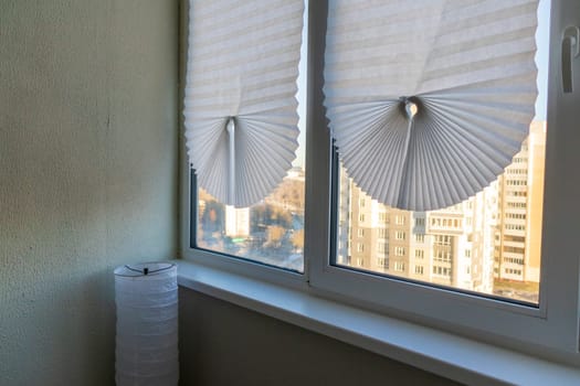 Paper blinds on the window in the balcony of the apartment