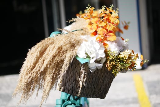 A beautiful arrangement of vibrant flowers and soft pampas grass situated in a stylish bike basket