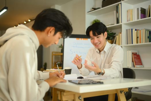 Tutor and student sharing ideas and discussing study materials during a home tutoring session.