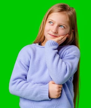 Young girl in a thoughtful pose with a green background in studio