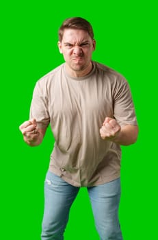 Man expressing intense frustration while standing against a bright green background in studio