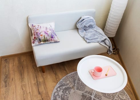 Interior of the balcony of the modern apartment. Sofa, coffee table, standing light