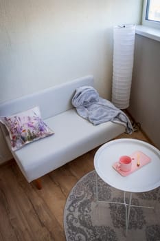 Interior of the balcony of the modern apartment. Sofa, coffee table, standing light
