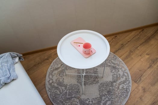 Coffee table with the pink cup for ladies on it