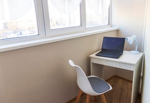 Tiny working space in the apartment. Laptop on the desk