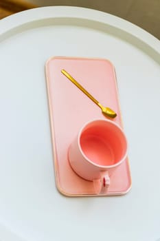 Coffee table with the pink cup for ladies on it.