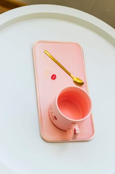 Coffee table with the pink cup for ladies on it.