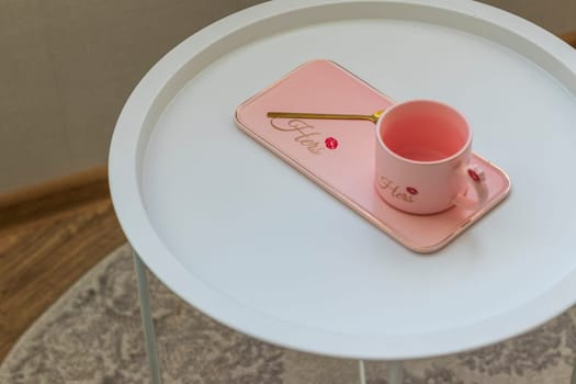 Coffee table with the pink cup for ladies on it.