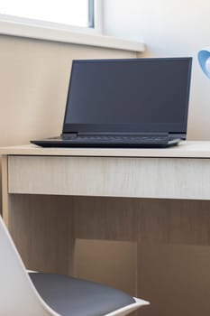 Tiny working space in the apartment. Laptop on the desk.