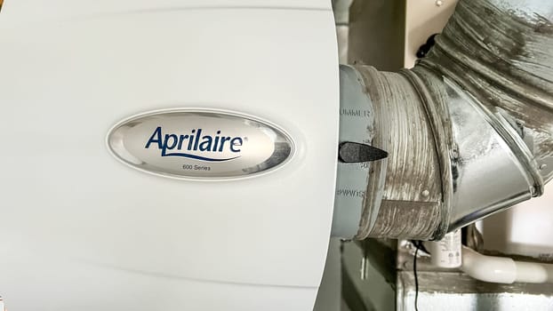 Parker, Colorado, USA-January 11, 2023-Close-up view of an HVAC system with a connected humidifier unit in a newly constructed residential home The image showcases ductwork pipes and electrical components highlighting the mechanical setup in the house