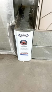 Parker, Colorado, USA-January 11, 2023-Close-up view of an Aprilaire air filtration unit installed alongside the HVAC furnace in the basement of a newly constructed residential home. The system is designed to improve indoor air quality by filtering dust, allergens, and other particles.
