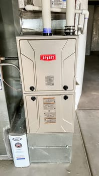 Parker, Colorado, USA-January 11, 2023-Close-up image of a Bryant HVAC furnace system installed in the basement of a newly constructed residential home. The image shows ductwork, ventilation pipes, and a filtration unit, highlighting the heating setup in the house.