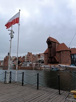 Gdanks, Poland - 11 December 2024: Poland flag in Gdanks old city Zuraw Motlawa river historical . High quality photo