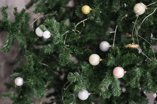 A beautifully decorated Christmas tree is adorned with a variety of softcolored ornaments all around it