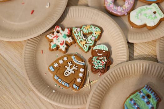 Delightful festive gingerbread cookies adorned with colorful icing and charming decorations on paper plates