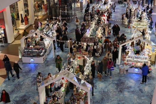 The holiday market is bustling with visitors enjoying festive stalls and beautiful decorations everywhere