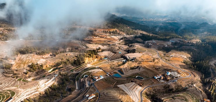 Dramatic view of a beautiful village and terraces with vineyards of Vilaflor, Tenerife Canary Islands, scenic view from above from a drone of a sunny picturesque valley and clouds.