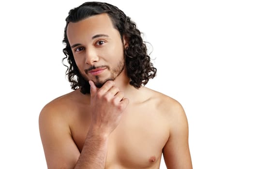 Young man with curly hair thoughtfully posing against a plain background in a studio setting