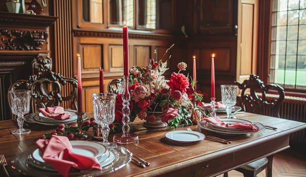 Festive table setting with candles and arrangement of beautiful red flowers. Holiday concept. High quality photo