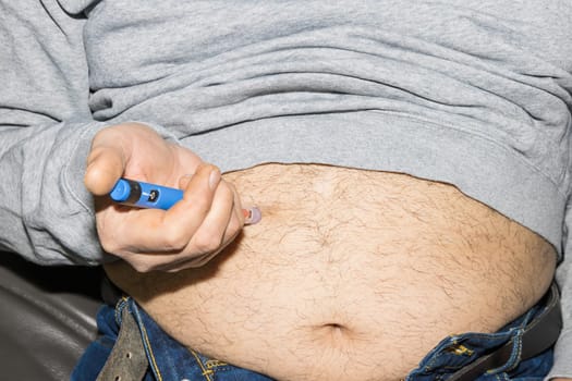 Diabetic man injects himself with Ozempic Insulin injection pen for diabetics.