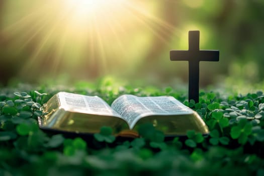 a bible book and a cross lying on the green clover leaves..