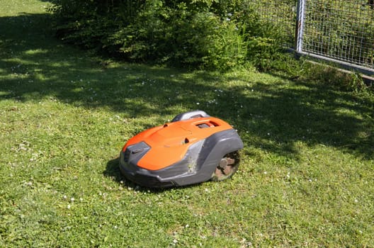 Robotic lawn mower on grass side view. Robot for the garden. High quality photo