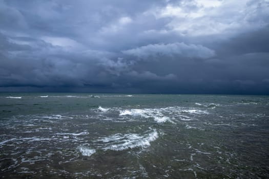 Dramatic seascape in dark colors. Dark sky with clouds over the stormy sea. High quality photo