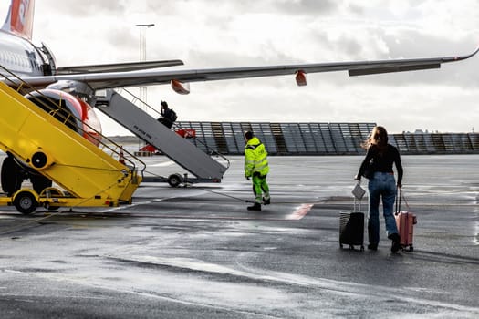 Easy Jet plane parked at Copenhagen airport. People boarding to the airplane. Copenhagen, Denmark - November 27, 2024