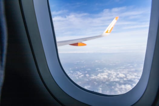 View from airplane window to earth, clouds and airplane wing. High quality photo
