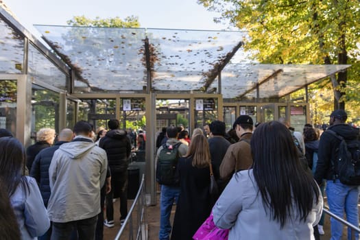 A long line of people stands at the entrance to the Eiffel Tower landmark in Paris, France - November 11, 2024