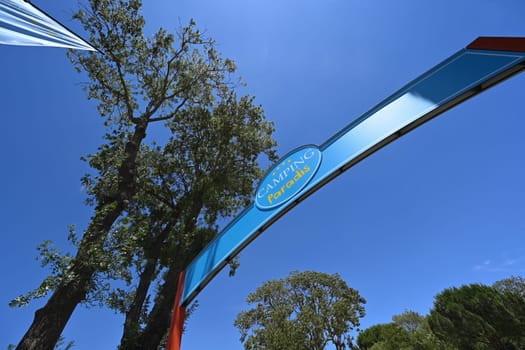 Camping Paradis sign, four stars against a blue sky in Port Grimaud. High quality photo