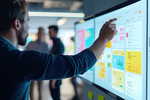 A web developer interacts with a digital interface on a screen in a modern workspace, showcasing user experience design and collaborative efforts.