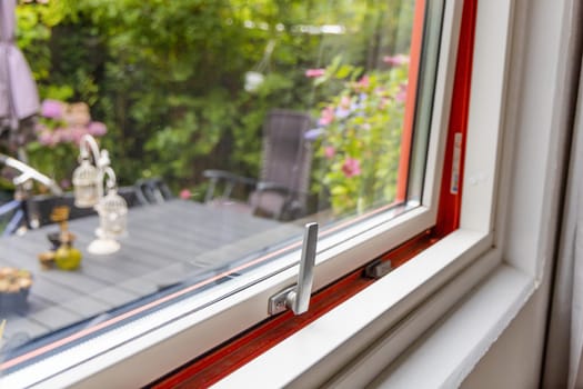 View from the window to the garden in the summer on a sunny day. Ajar window. . High quality photo