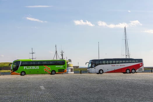 Two large tourist busses in an empty parking lot. Helsingor, Denmark - October 5, 2024