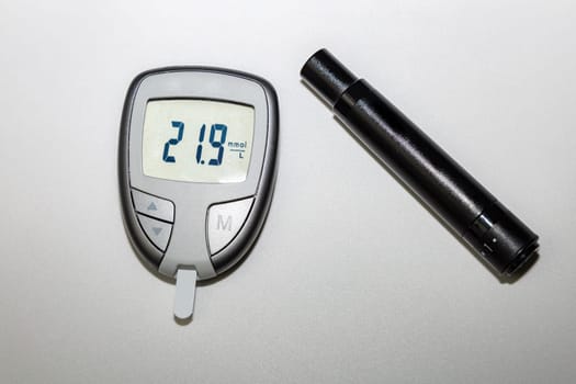 Blood sugar meter with test strips indicates high blood sugar levels. High quality photo