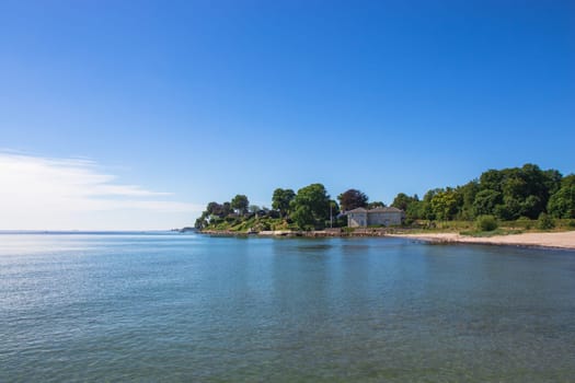 Coastline with houses at the Danish coast. View to beautiful landscape. North sea coast. House by the sea.