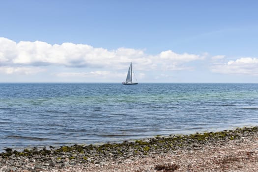Beautiful seascape. Sailboat floats on the blue sea. High quality photo